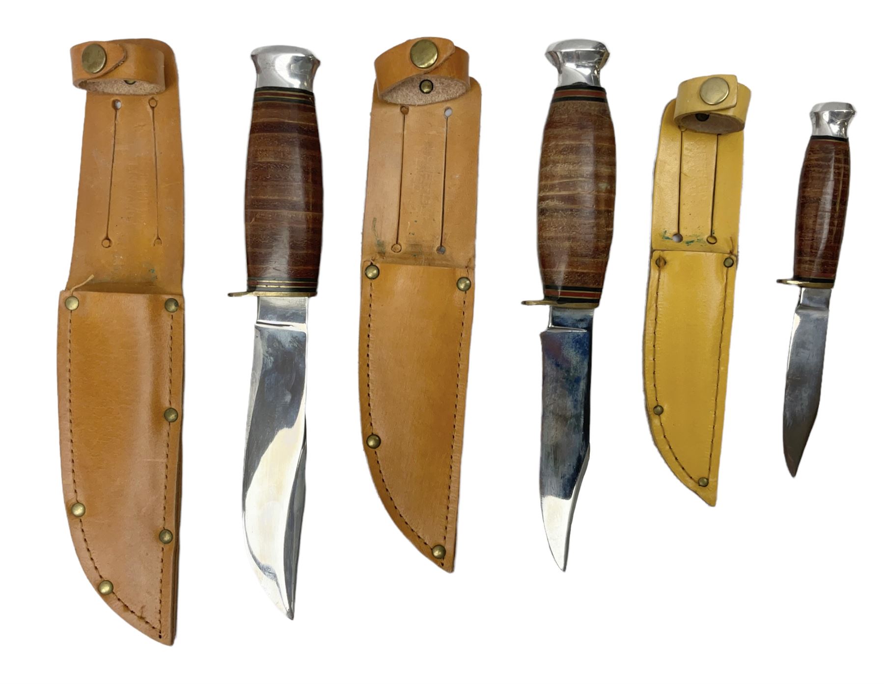 Graduated set of three Bowie knives by J. Nowill & Sons Sheffield England Est. AD1700, each with steel blade, brass cross-piece, stacked leather type grip and alloy pommel; largest blade 13cm and smallest 7.5cm; each in leather sheath (3)
