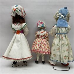 Anna Meszaros Hungary - three hand made needlewrok figurines - each wearing a lon floral dress and bonnet and holding a bouquet of flowers, tallest H32cm (3)  Auctioneer's Note: Anna Meszaros came to England from her native Hungary in 1959 to marry an English businessman she met while demonstrating her art at the 1958 Brussels Exhibition. Shortly before she left for England she was awarded the title of Folk Artist Master by the Hungarian Government. Anna was a gifted painter of mainly portraits and sculptress before starting to make her figurines which are completely hand made and unique, each with a character and expression of its own. The hands, feet and face are sculptured by layering the material and pulling the features into place with needle and thread. She died in Hull in 1998.