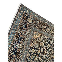 Persian Kashan indigo ground rug, the rosette medallion decorated with projecting palmettes, on a field of swirling leafy branches and decorated with further palmettes, the scrolling border with repeating stylised plant motifs, within floral pattern guard stripes