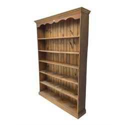 Large pine open bookcase, projecting cornice and shaped frieze over five shelves