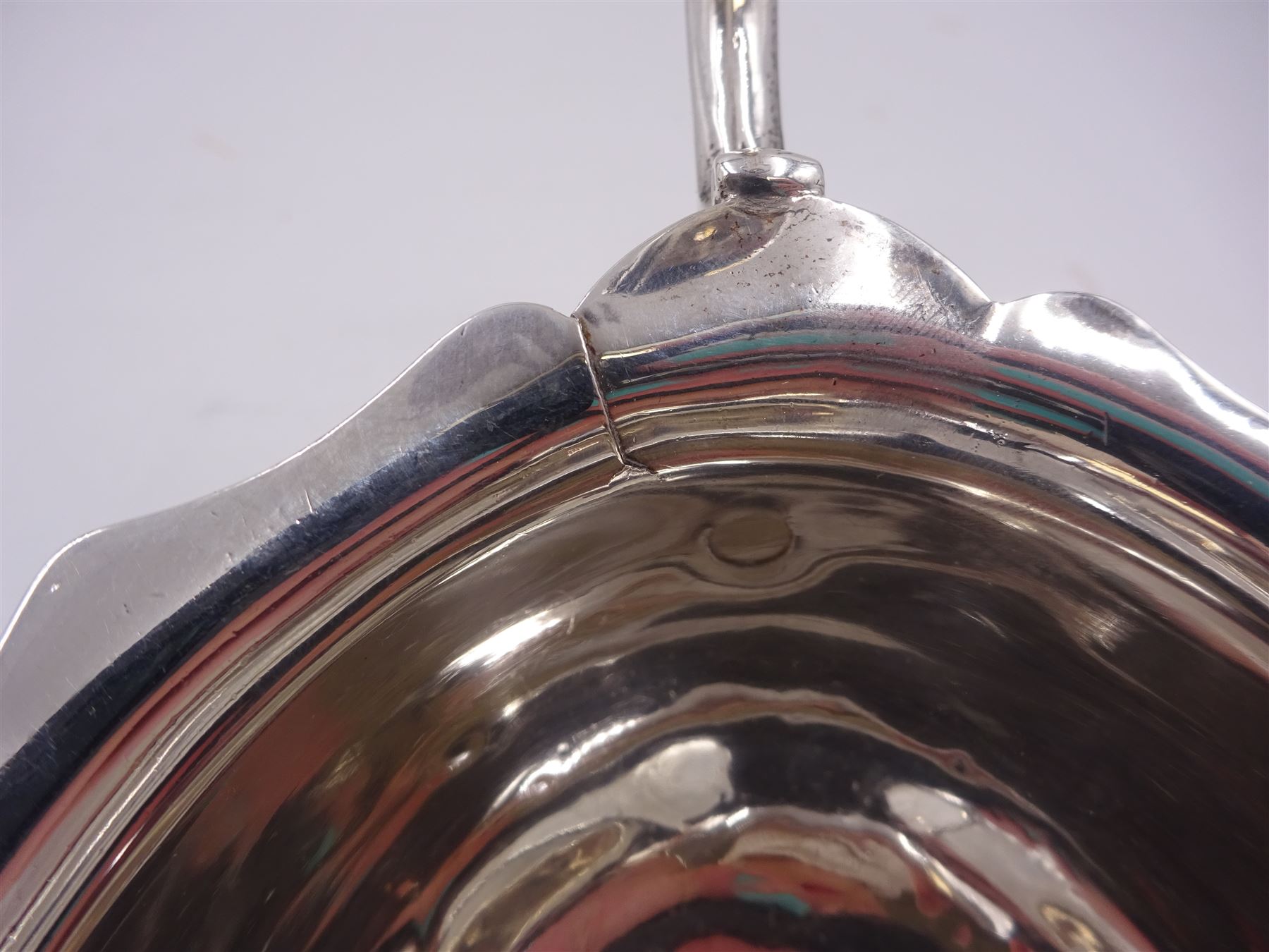 Victorian silver sauce boat, of typical plain form, with shaped rim and acanthus capped flying scroll handle, upon three hoof feet, hallmarked Walker and Hall, Sheffield 1899, including handle H12cm