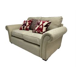Two seater sofa, upholstered in cream fabric