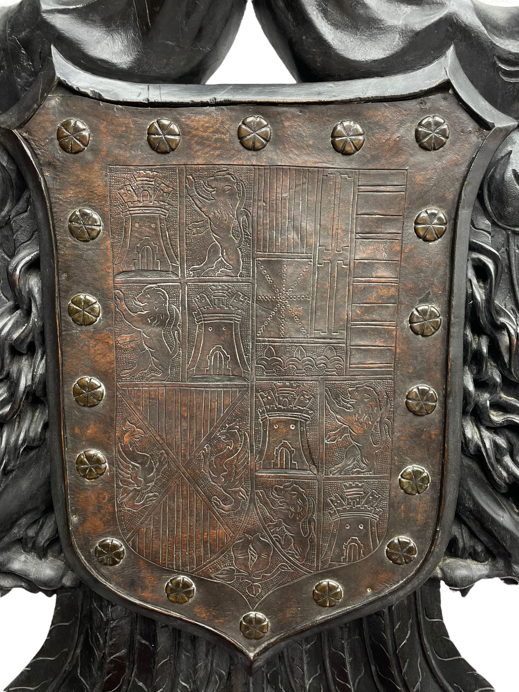 Grand mid-to-late 19th century heavily carved beech framed throne chair, the crown pediment carved with flower heads and cross finial, scroll and acanthus carved upright supports with twin perching griffin back enclosing etched leather work heraldic shield with castle and lion motifs over splayed feathers, flower head carved down sweeping arms with grotesque carved terminals, the seat rails carved with further flower heads on moulded supports with oversized ball and claw carved feet

Provenance: A very similar chair was used in the filming of Stanley Kubrick's 'Eyes Wide Shut' (1999)
