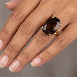 14ct gold smokey quartz ring, four claw set with a single oval cut quartz, stamped