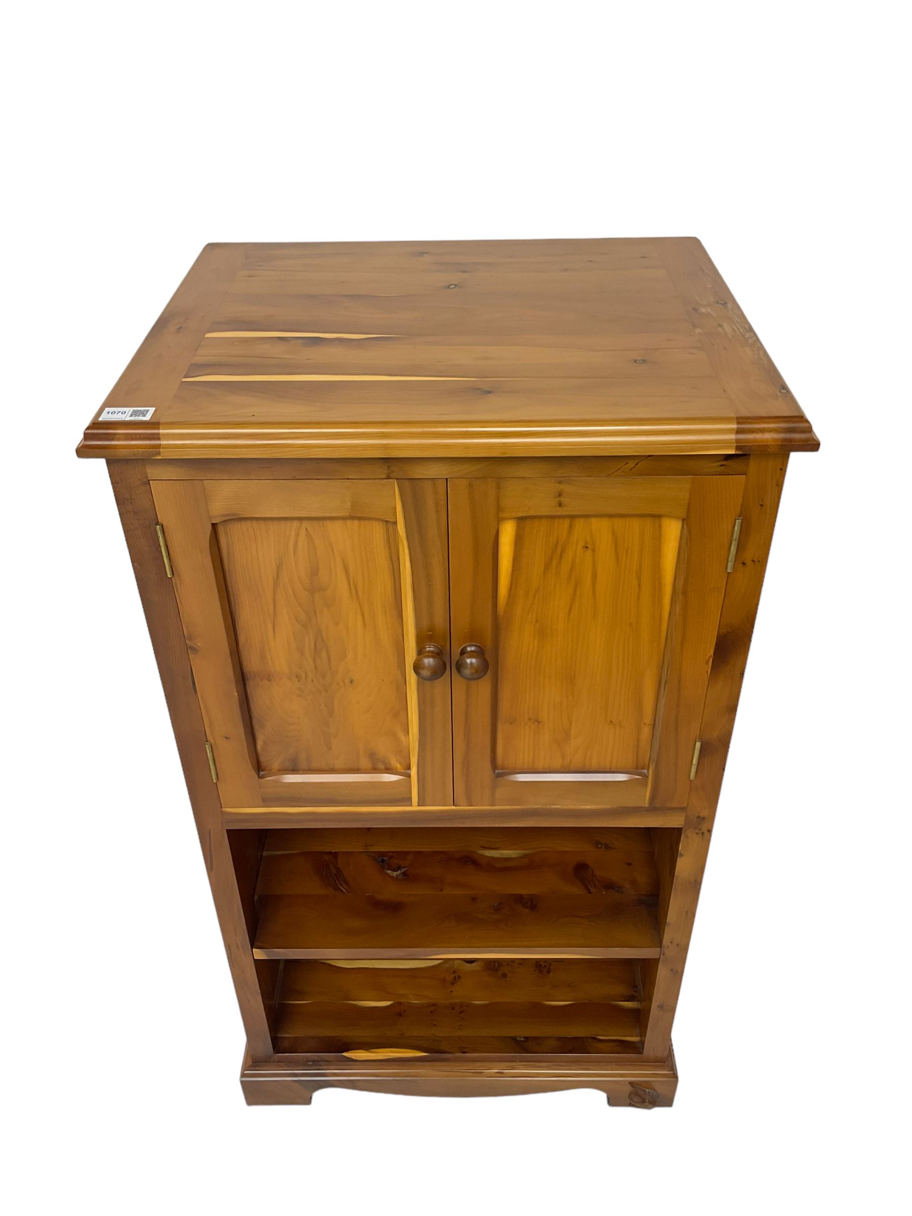 Unicornman - yew wood cabinet, moulded hinged lid over two panelled doors and shelves (W56cm, H99cm, D45cm); and four Unicorn man CD racks two in yew wood and two in oak (W20cm, H36cm, D20cm); all carved with unicorn signature and by Geoff Gell, Coxwold
