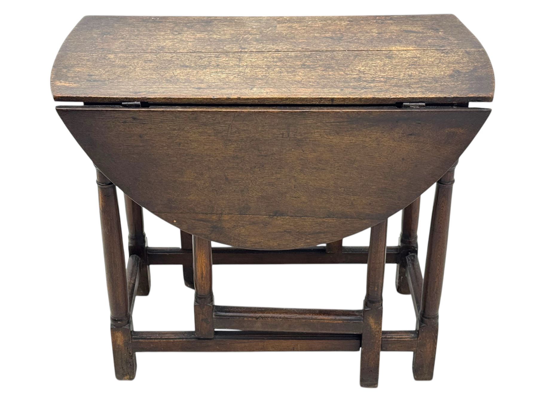 19th century oak gateleg table, the oval drop-leaf top formed of four planks, on turned column supports united by rectangular stretchers