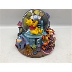 Five Disney Winnie The Pooh snow globes, to include Pooh and Piglet Sailing, Pooh's Grand Adventure and Blustery Day, together with The Walt Disney Classic Waterglobe collection globe and group Tigger, Winnie and Piglet figure under dome, all with boxes (7)