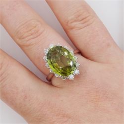 18ct white gold alexandrite and diamond cluster ring, the natural oval cut green alexandrite of approx 5.95 carat, surrounded by fourteen round brilliant cut diamonds, stamped 750, total diamond weight approx 0.80 carat