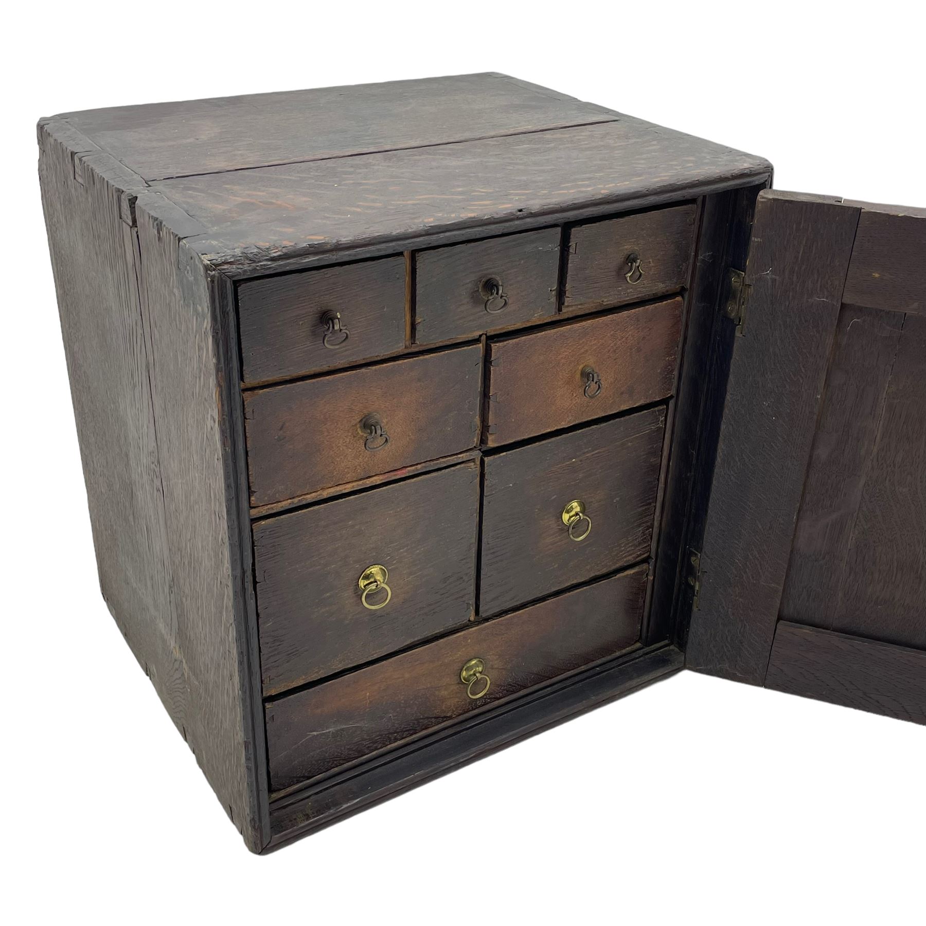 18th century oak spice cupboard, single panelled door enclosing eight drawers of various sizes, reed moulded front edges