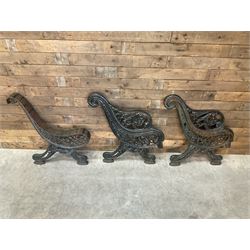 Early 20th century heavy cast iron three piece bench ends, decorated with scrolls and floral swags