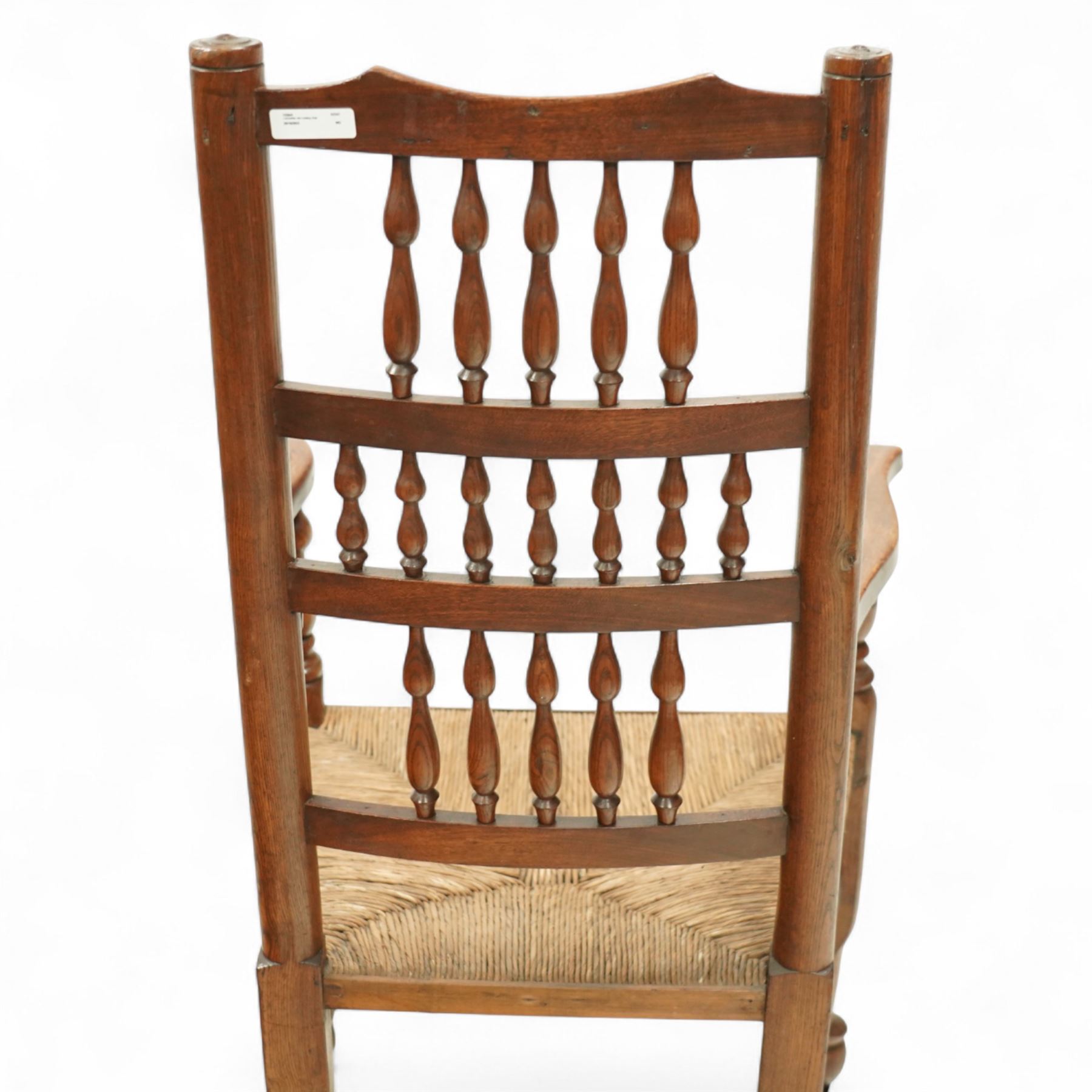 Lancashire elm rocking chair, shaped cresting rail over triple row bobbin turned spindles, woven rush seat, on curved rockers