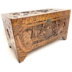 Early 20th century camphor wood chest, heavily carved depicting urban scene, bracket supports 