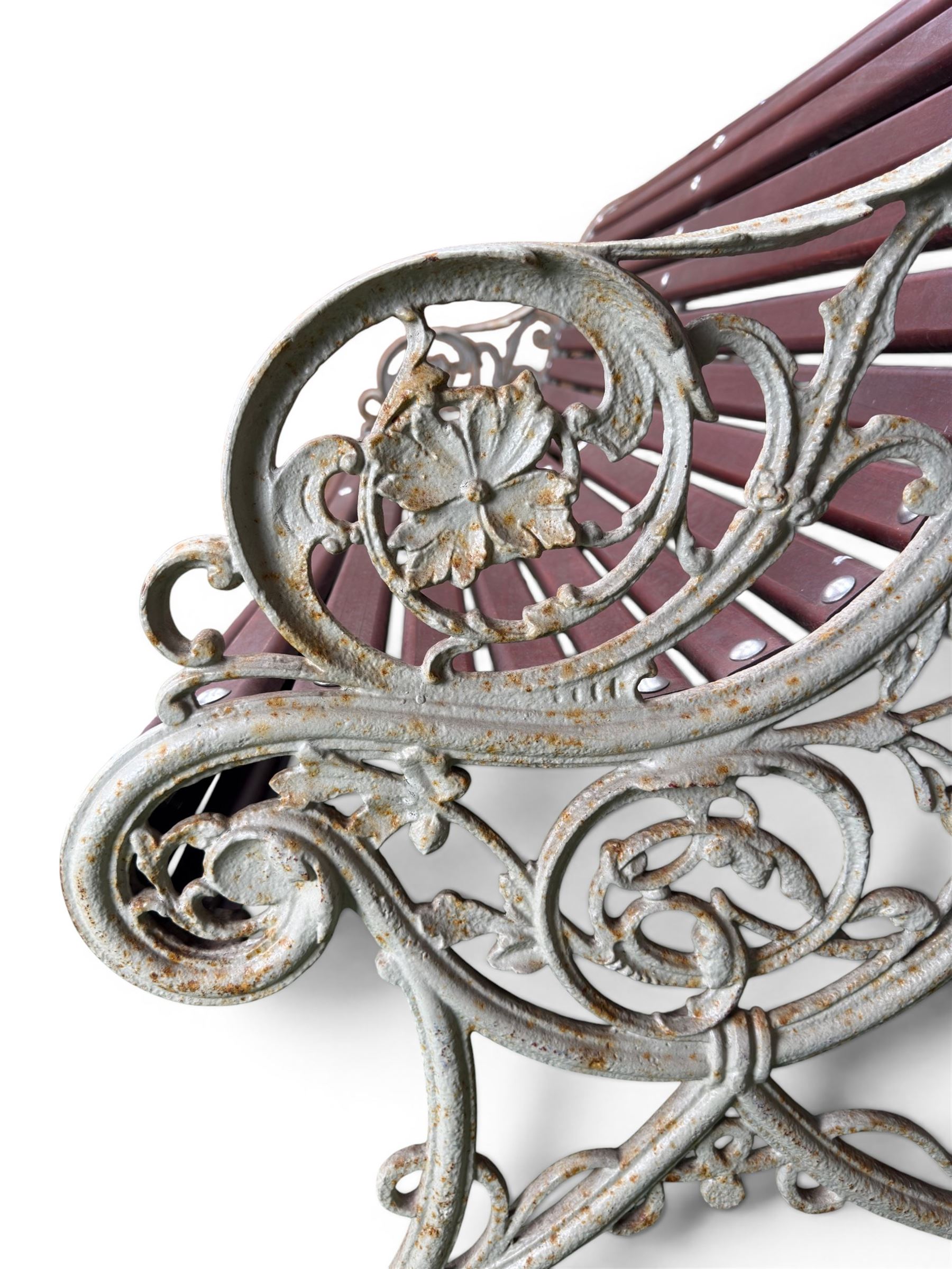 Large late Victorian cast iron garden bench, serpentine form with scroll back and seat, slatted with mahogany stained Sapele