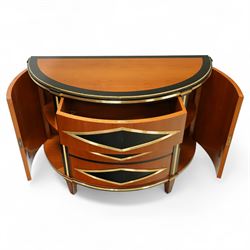 Colombo Mobili - Pair of Italian designer cherrywood art-deco inspired demi-lune commode cabinets, the shaped top with ebonised inlay and gilt brass repeating anthemion beading above a gilt brass reeded moulding, over three long drawers with gilt brass geometric panel mounts, flanked by cupboard doors with diamond motif, raised on tapering square supports 