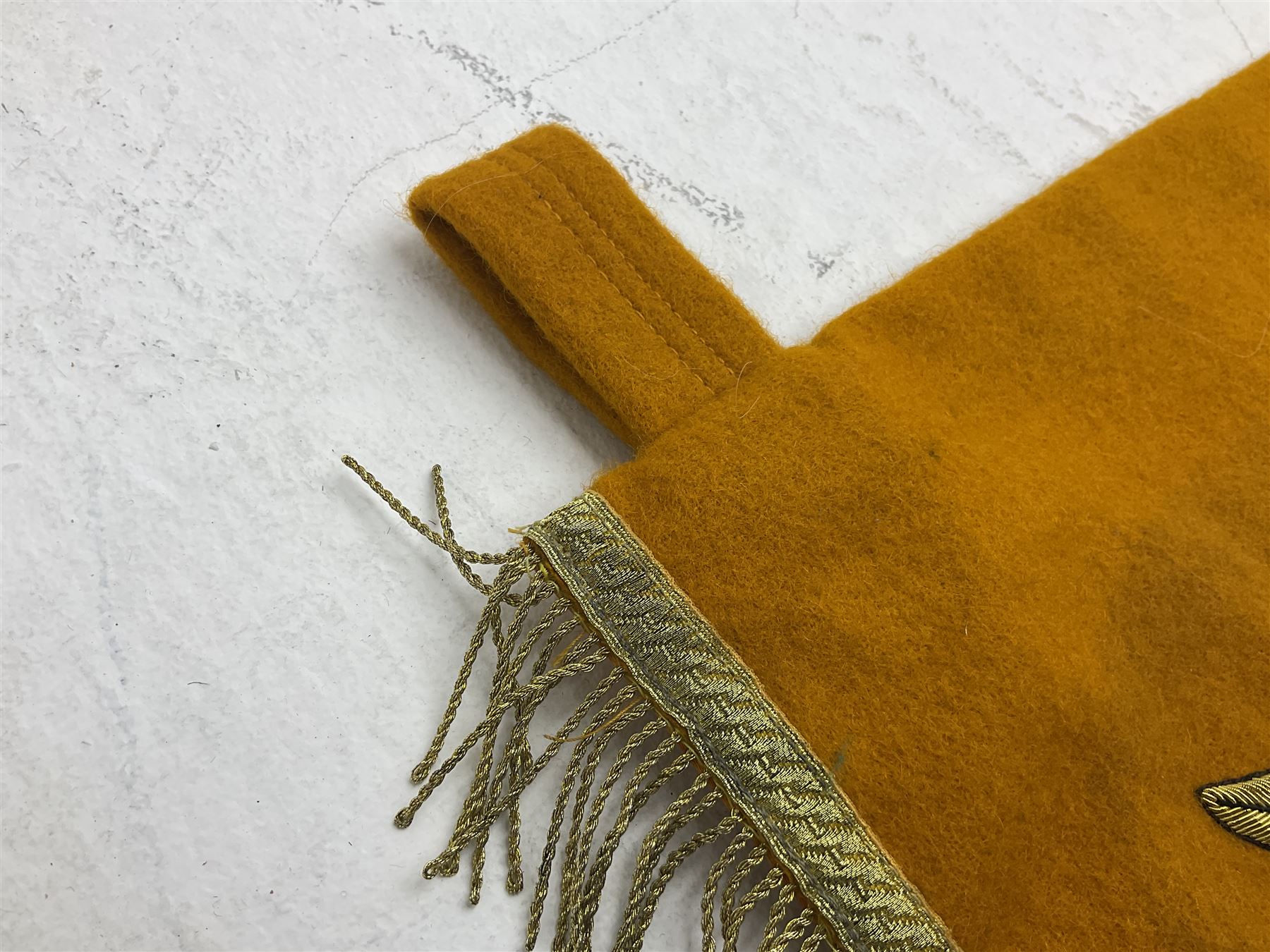 Two replica German Luftwaffe trumpet banners, one heavily silver wire embroidered with Luftwaffe eagle in a wreath, on an amber, white and black rayed background, , with silver wire tasselled border and four leather hanging loops, approx. 50 x 49cm; the other slightly larger heavily gold wire embroidered with the Luftwaffe eagle on a plain amber ground with gold wire tasselled border and two hanging loops (2)