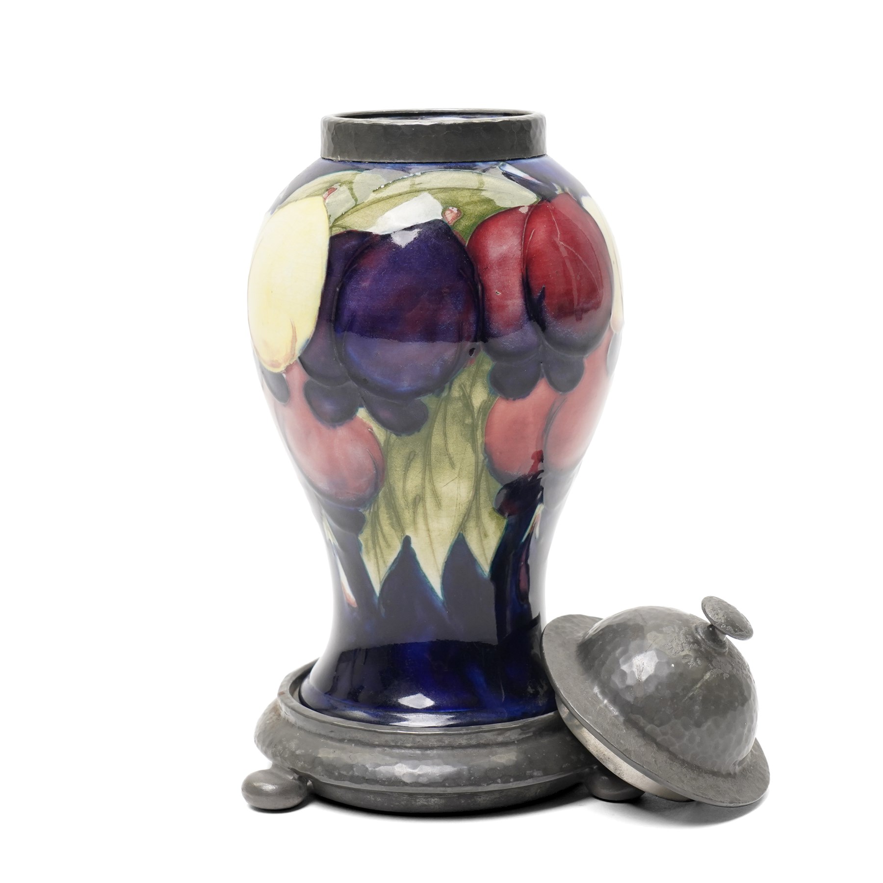 William Moorcroft for Liberty Wisteria pattern baluster vase on a dark blue ground with planished domed pewter cover and collar on a pewter stand marked Tudric Moorcroft 01308 Overall height 21cm