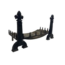Cast iron fire-dogs or andirons with fire basket, with fleur-de-lis finial over moulded and tapered upright, arched feet