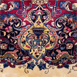 Large North East Persian Meshed hand-knotted carpet with signature, raspberry red field with central shaped cusped medallion, densely decorated with intricate arrangement of scrolling vines, and florals designs within conforming spandrels and a dark ground border richly ornamented with stylized flowers, vase and bird ornamentation, enclosed by guard stripes, with cotton fringe ends