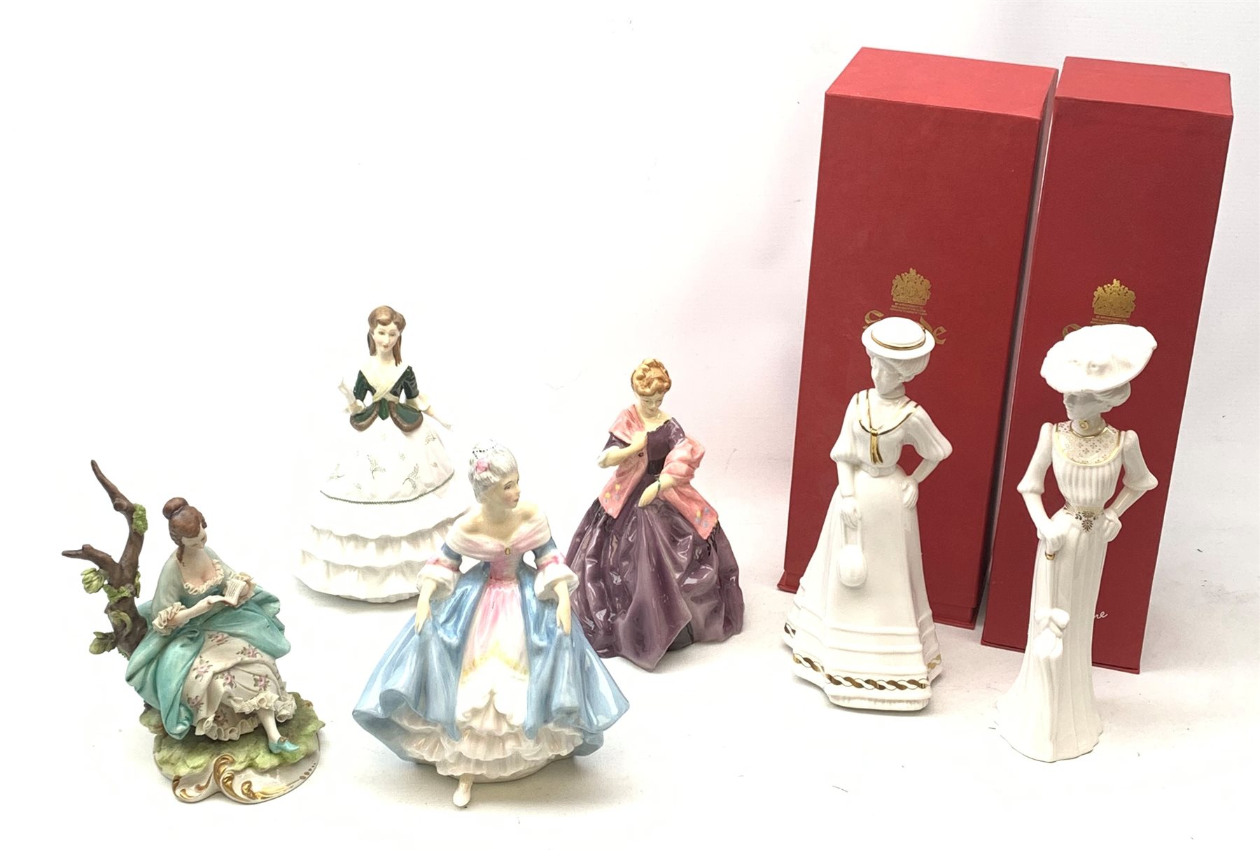 A group of figurines, comprising two boxed Spode Pauline Shine examples, Lily and Olivia (one a/f), a Royal Douton figurine First Dance modelled by F G Doughty, a further Royal Doulton figurine, Debutante, a Royal Doulton figurine, Southern Belle HN2425, and an unmarked continental figurine. 