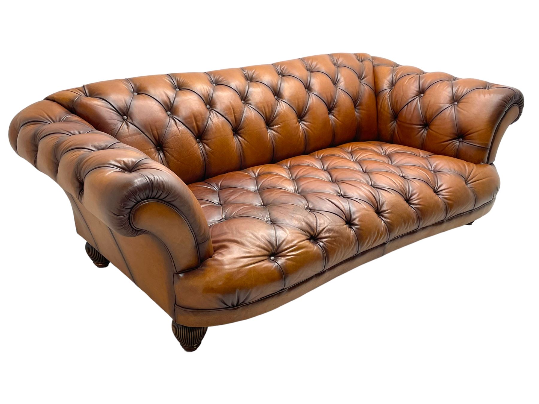 Tetrad - 'Oskar' grande three-seat sofa, Chesterfield shape with rolled arms, upholstered in buttoned tan leather, on turned and reed moulded feet 