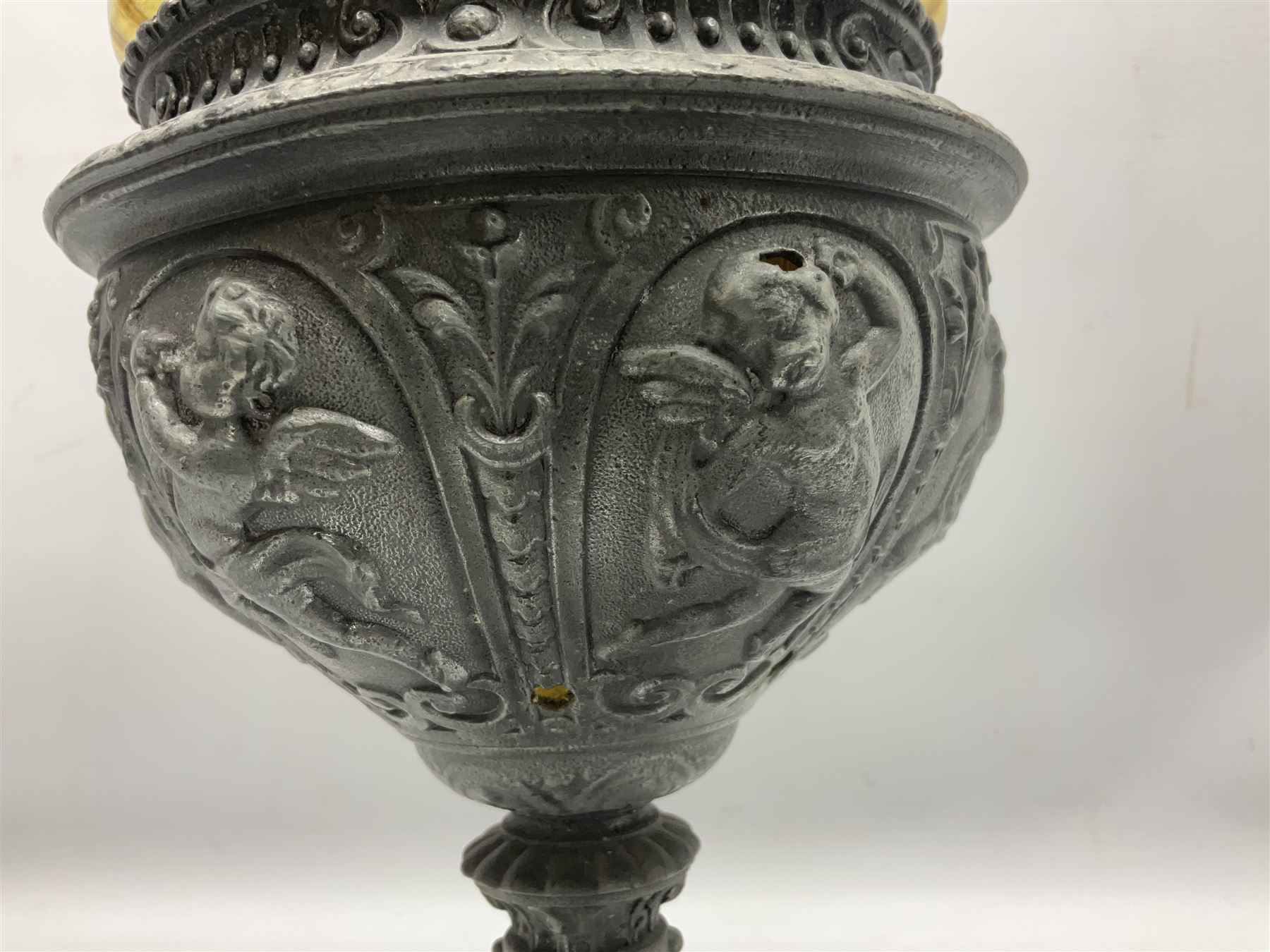 Victorian cast spelter oil lamp, decorated with cherubs and foliate scrolls, supporting a glass reservoir, burner and clear glass chimney, H62cm