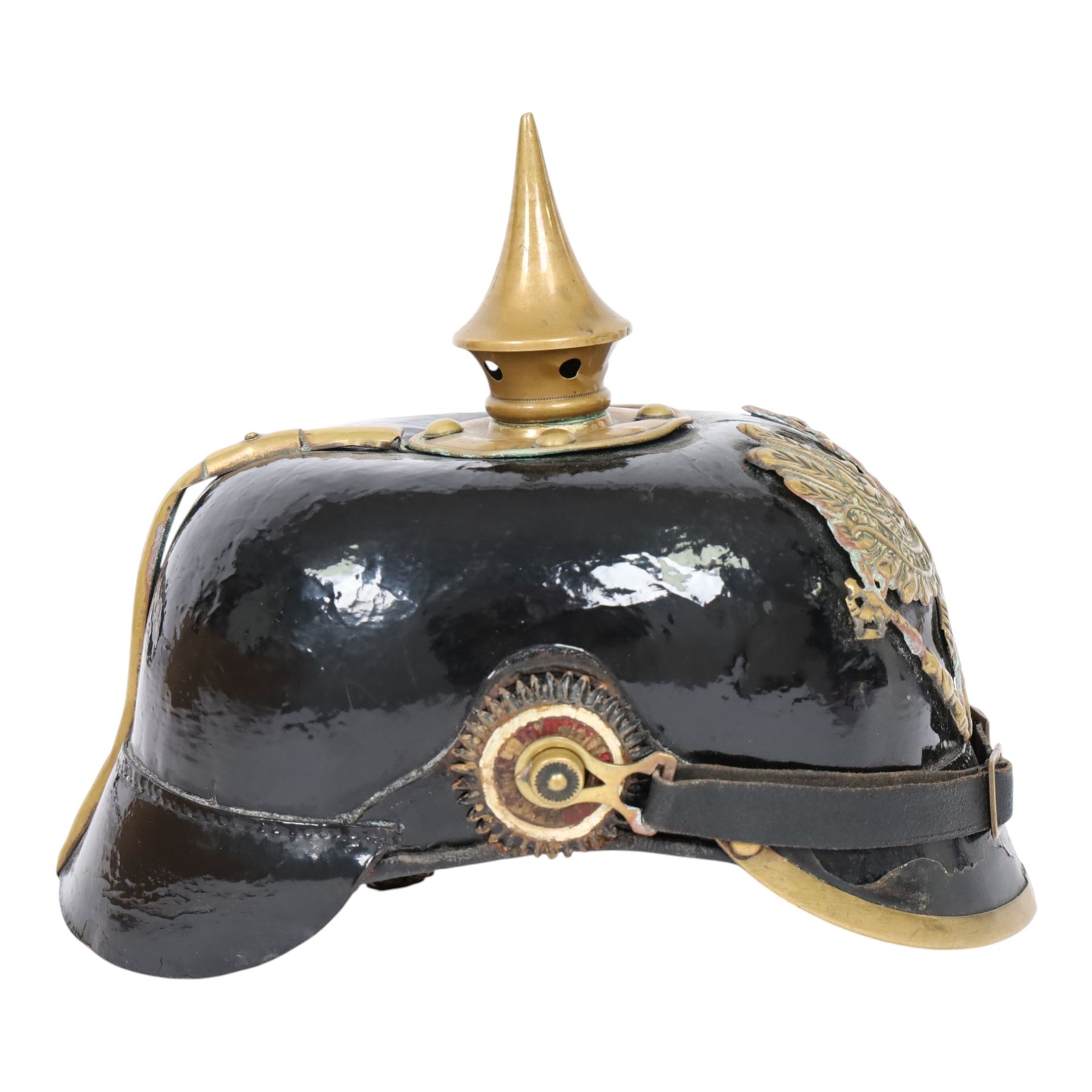 WWI Prussian M1895 Pickelhaube, the black leather skull with brass spike finial, brass eagle helmet plate and leather chin strap, one side with a black cockade,  the other black and red, with leather lining