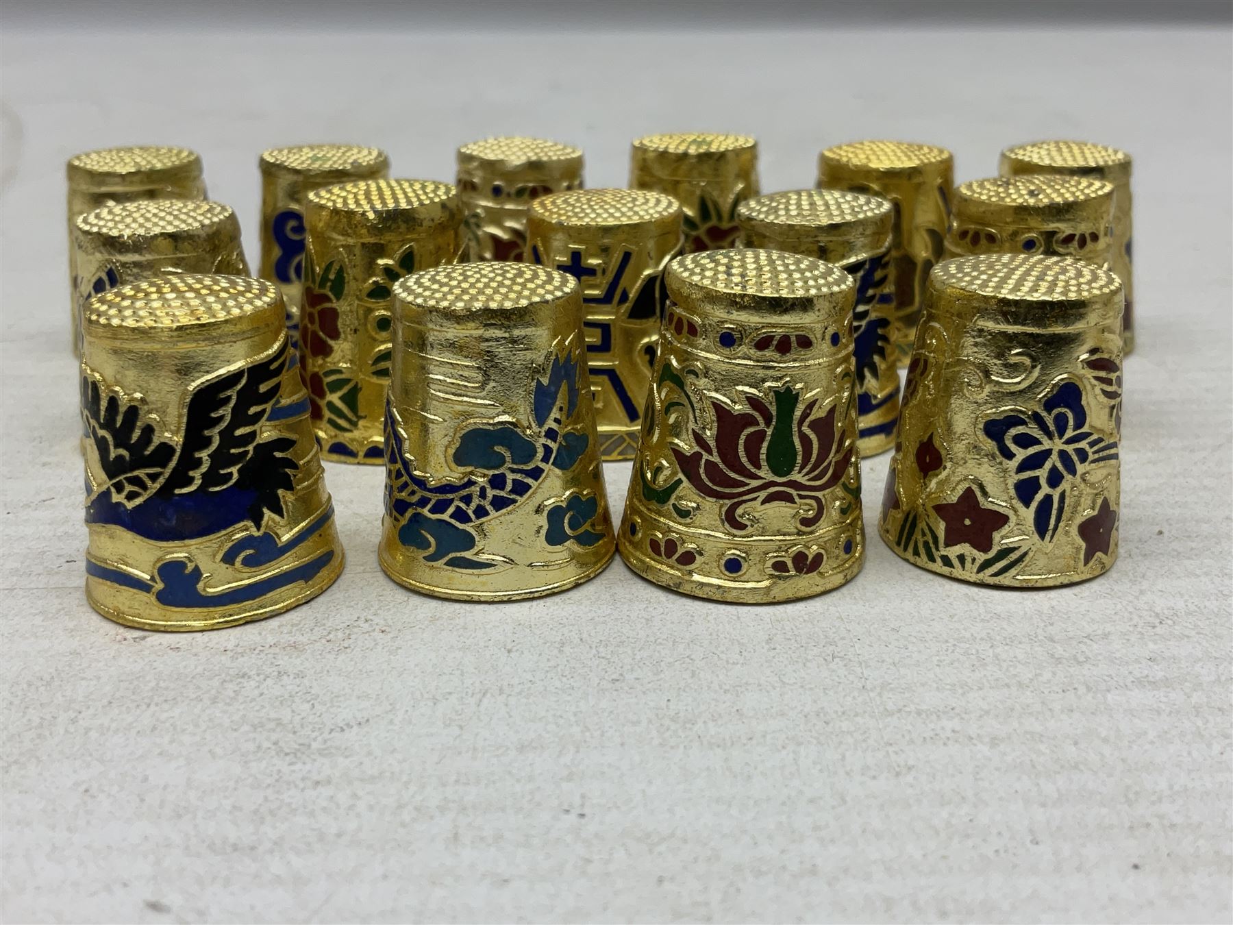 Twenty cloisonné thimbles, decorated with, flowers, birds, dragons
