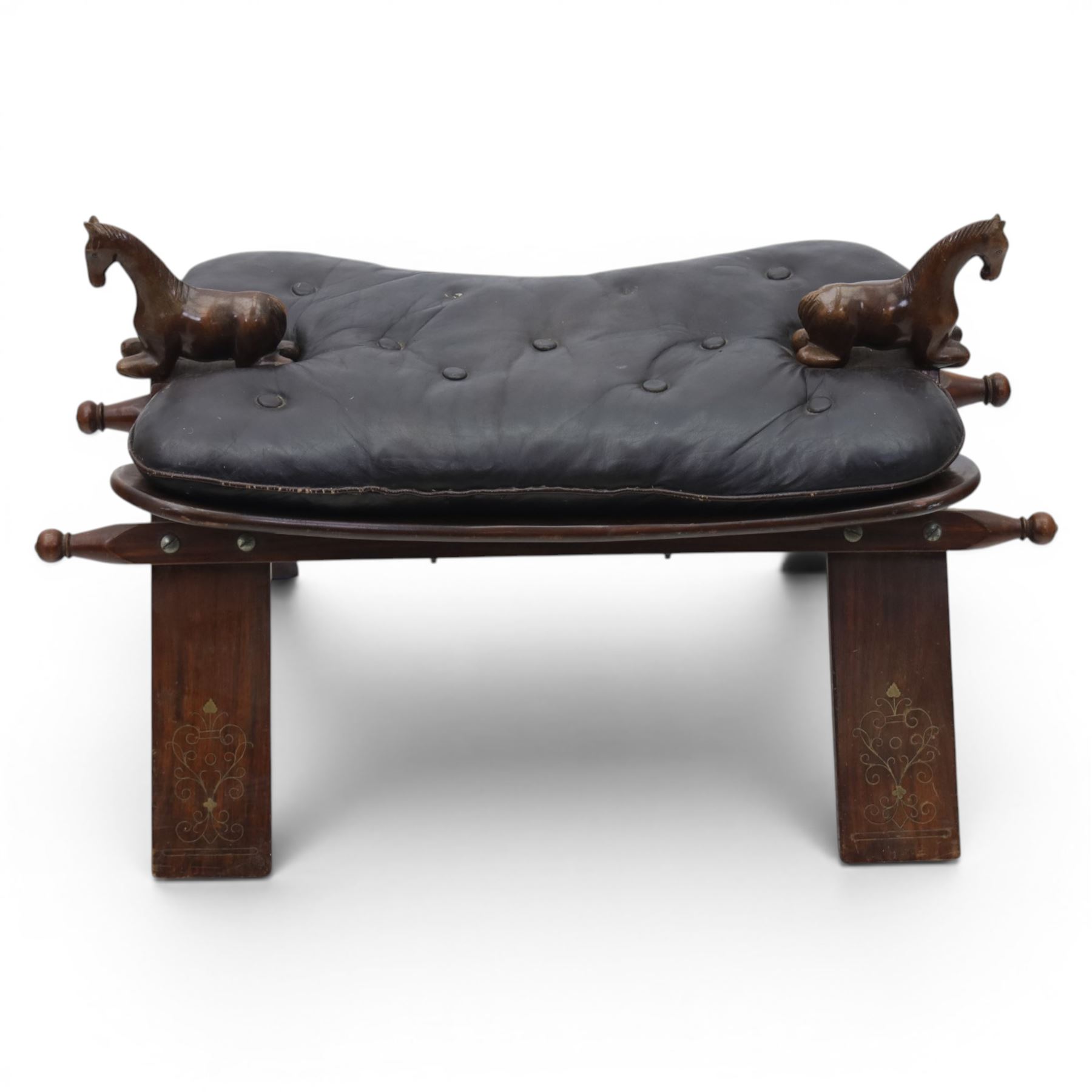20th century saddle stool, wiht black leather seat, surmounted with carved horses, on an X-frame base with brass inlay