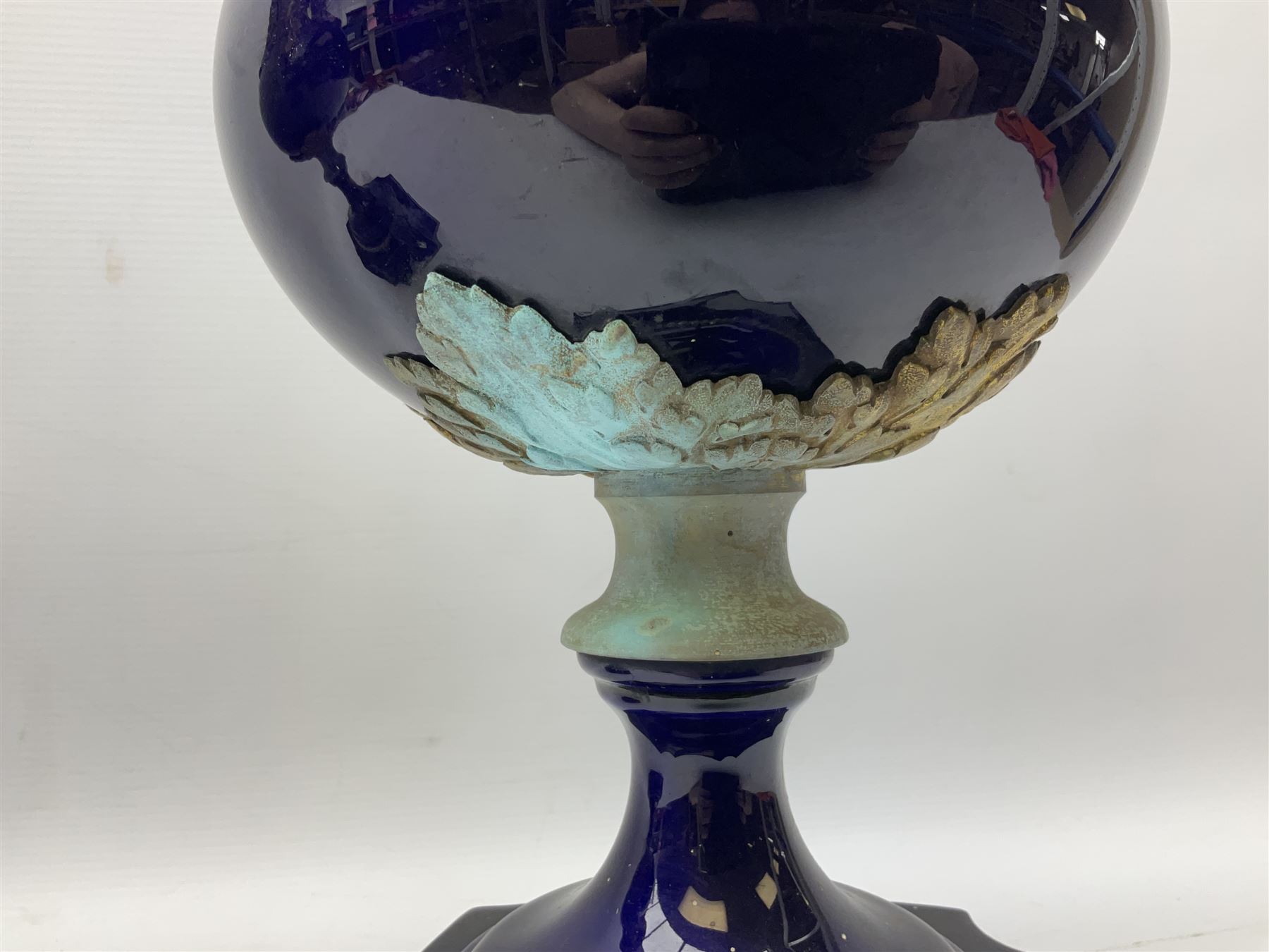 Pair of French large cobalt blue lidded urns, probably 19th century, the body decorated with ormolu ram's heads and ornate foliate design, the domed cover with brass berry finial, raised upon pedestal base with beaded decoration upon shaped plinth, H52cm