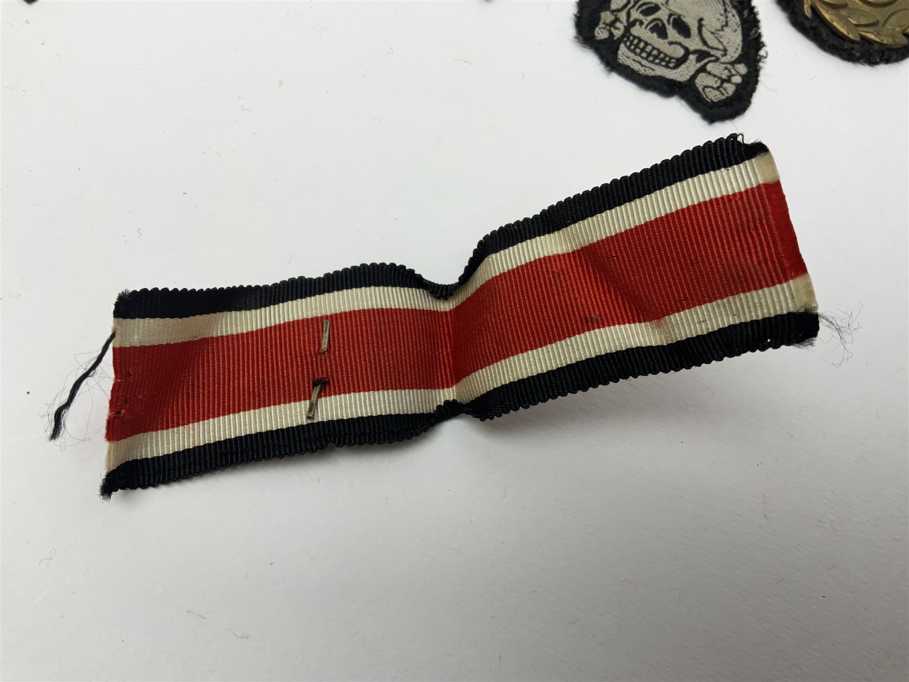 Collection of eleven German metal and cloth badges and uniform buttons including driver's badge, two 'SS' fabric skulls, private's shoulder tabs, Police cloth badge, tank destruction badge, medal bars and ribbon etc; most WW2 period