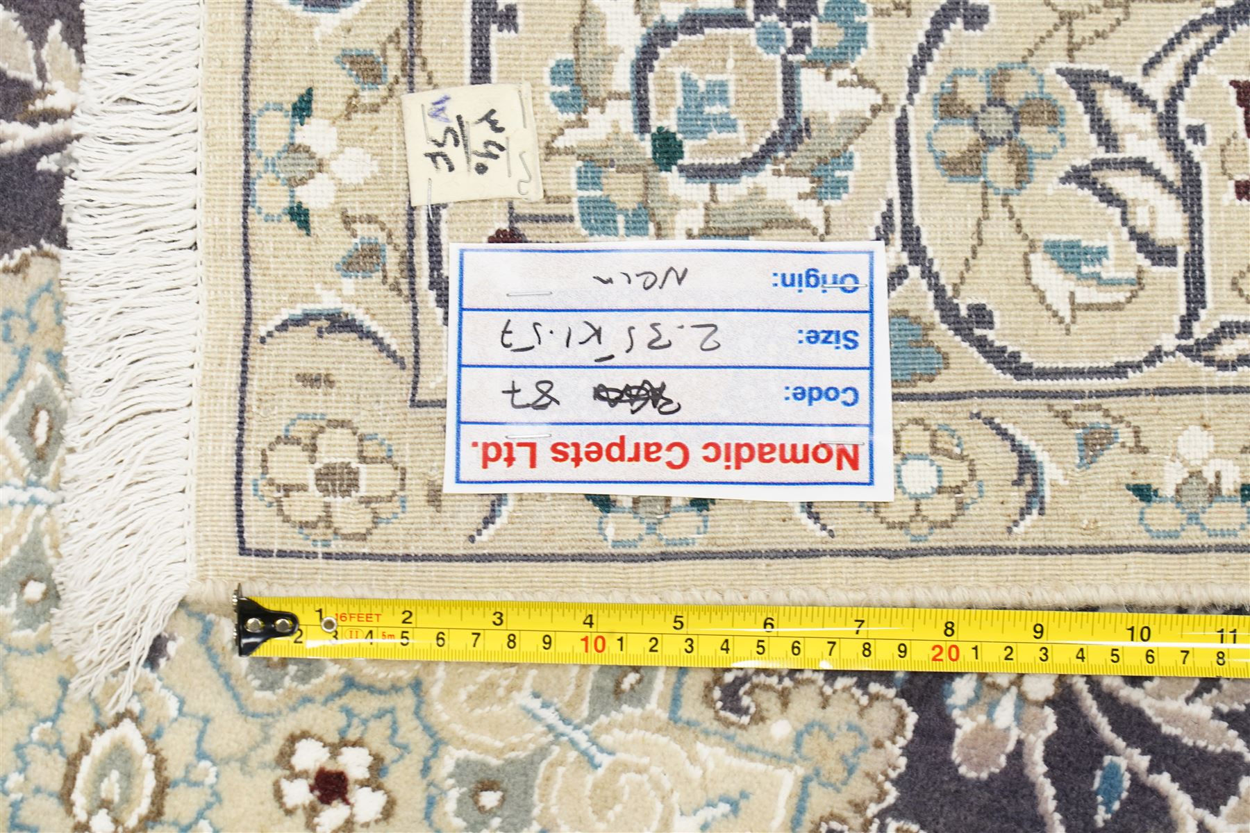 Central Persian Nain hand-knotted carpet, indigo field with central cusped medallion of radiating palmette form, enclosed with an elongated cartouche issuing network of scrolling vine work, arabesques and flowering sprays, surrounding ivory field of conforming design filled with foliate motifs and palmettes, spandrels of complimentary design with angular reserves, within principal border of ivory ground with scrolling vinery rosettes and arabesques, flanked by narrow guard stripes, with cotton fringe ends 