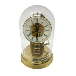  A late 20th century -  German Kieninger & Obergfell, “Kundo” battery operated
mantle clock under an acrylic shade, with an electrically operated solenoid pendulum housed on a circular brass base, skeleton movement with visible motion work through a painted 4-1/2” open chapter ring, with pierced steel hands, Roman numerals and minute track.