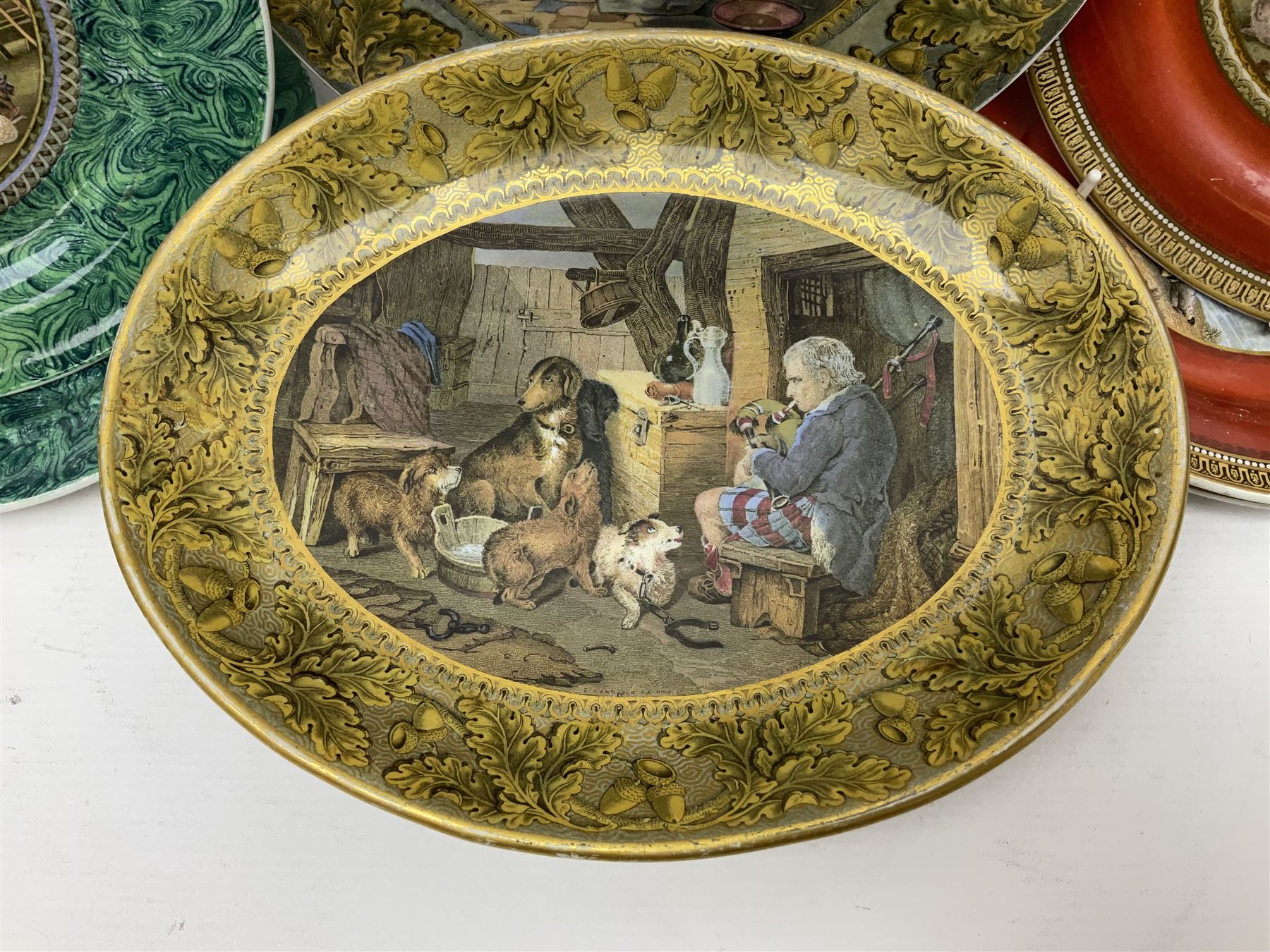 19th century Prattware table ware to include an oval footed dish decorated with a scene after Landseer 'Highland Music', retailed by James Muggleton L27.5cm, ‘The Truant’ plate after T. Webster, 'Blind Man's Buff' & 'Snap Dragon' tea plate, two side plates with malachite printed borders and others (17)