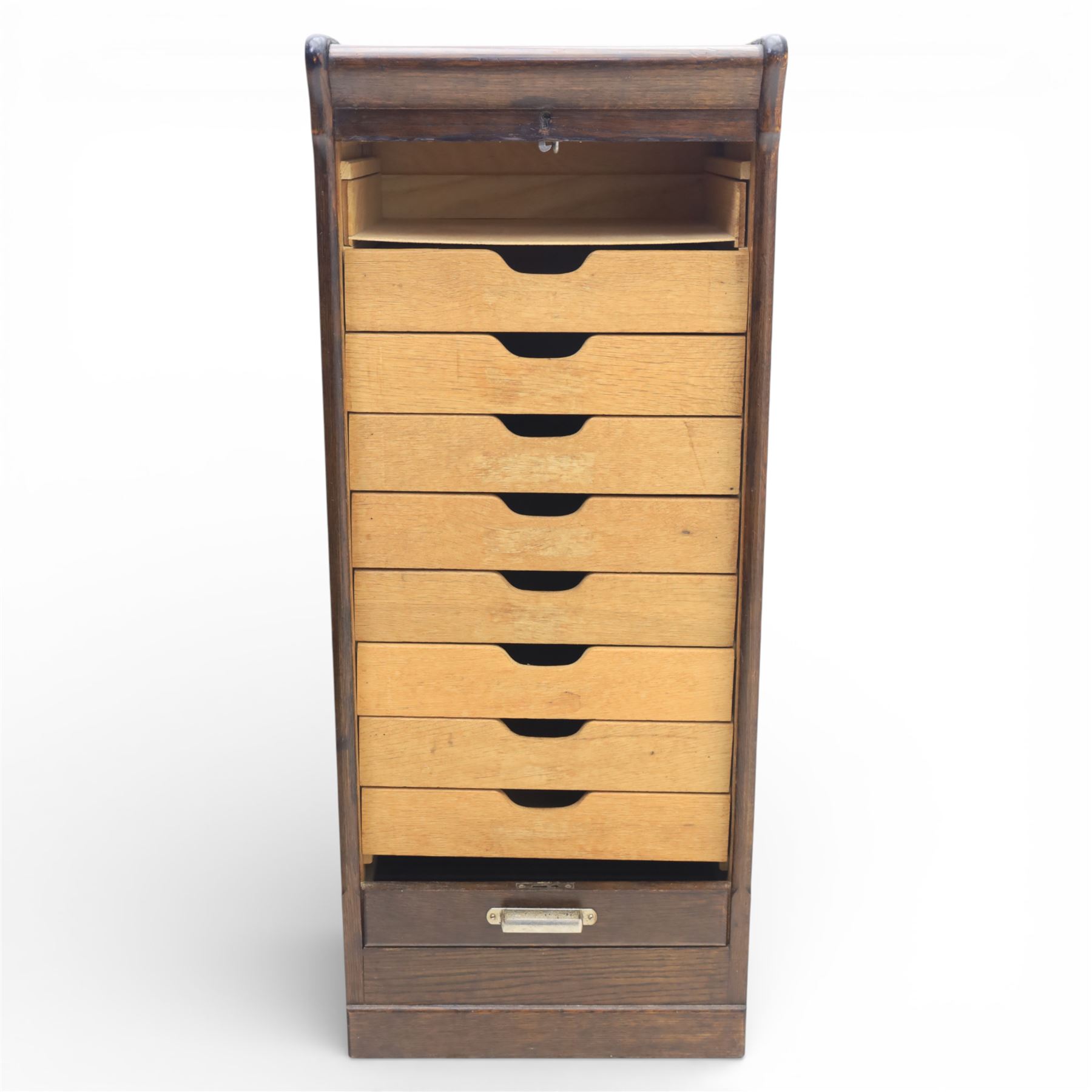 Early 20th century oak tambour front fitted cabinet, rectangular top with rounded corners over a roll tambour front enclosing a fitted interior of multiple shallow drawers with cut-out pulls, the sides with rounded uprights, on a stepped plinth base