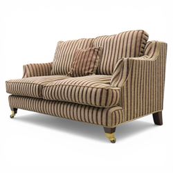 Late 20th century fabric upholstered sofa, with loose back and seat cushions, broad padded arms with piped borders, upholstered in striped textile, raised on concealed feet