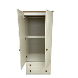 Cream and oak finish double wardrobe, two doors enclosing hanging rail over two drawers (74cm x 54cm x 183cm); cream and oak finish chest, fitted with four drawers (77cm x 42cm x 88cm); matching bedside chest fitted with three drawers (40cm x 42cm x 70cm)