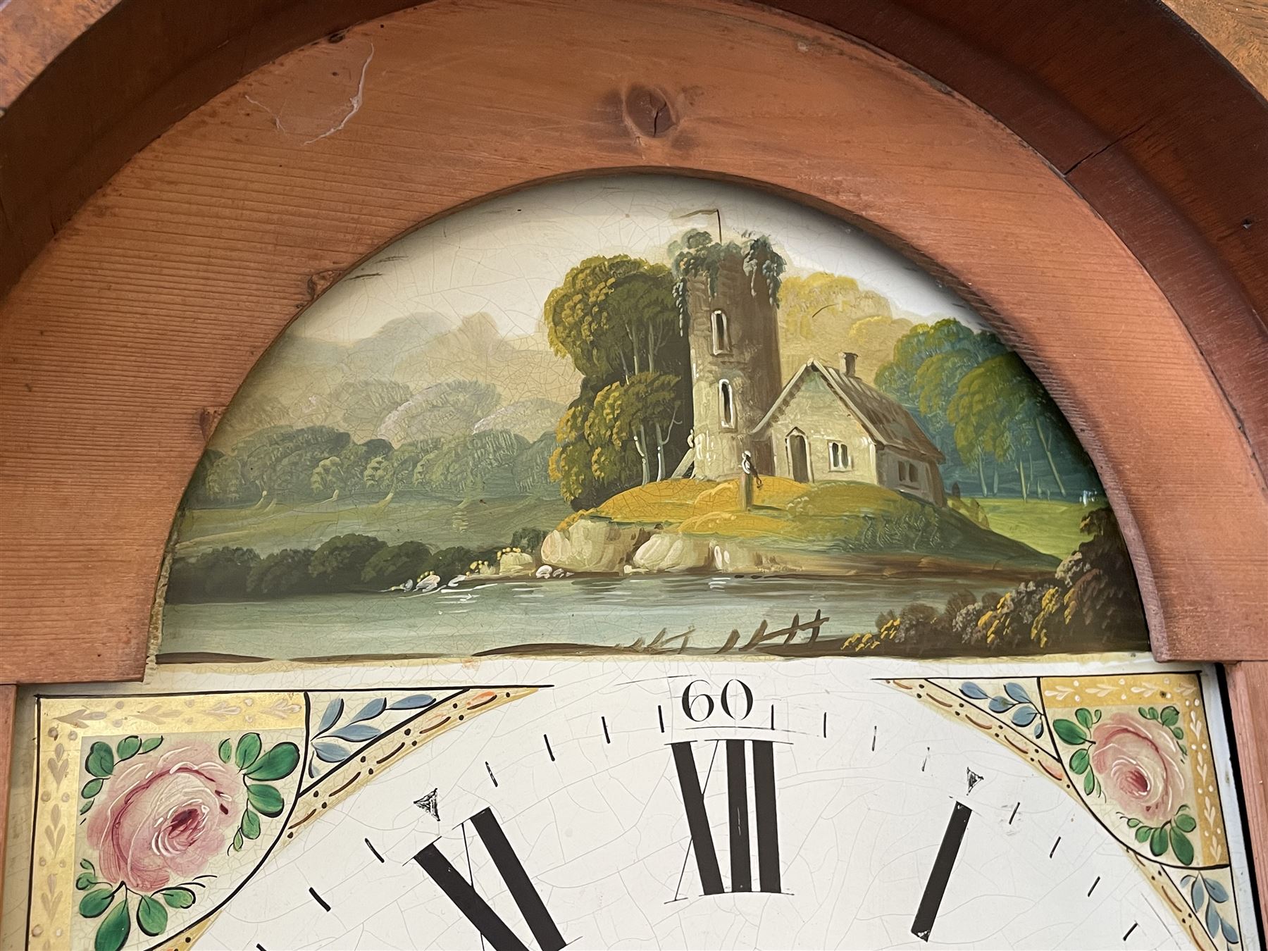 Thirty-hour oak cased longcase clock by  William Bancroft of Scarborough circa 1830, with a swan’s neck pediment, brass patera and three brass spire and ball finials, stepped break arch hood door flanked by plain pillars with brass capitals, trunk with a full length door and curved arch top, on a plain square plinth with bracket feet, painted break arch dial with roman numerals and quarter hour Arabic’s, date recorder (anti clockwise) and matching brass hands, arch painted with a rural scene depicting a ruined tower and cottage with depictions of flowers to the spandrels, dial pinned directly to a chain driven countwheel striking movement, striking the hours on a bell. With weight and pendulum. The Bancroft family were prodigious Scarborough clockmakers during the 18th and 19th century, William Bancroft is recorded as working in Newborough Street from 1820 onwards. 


