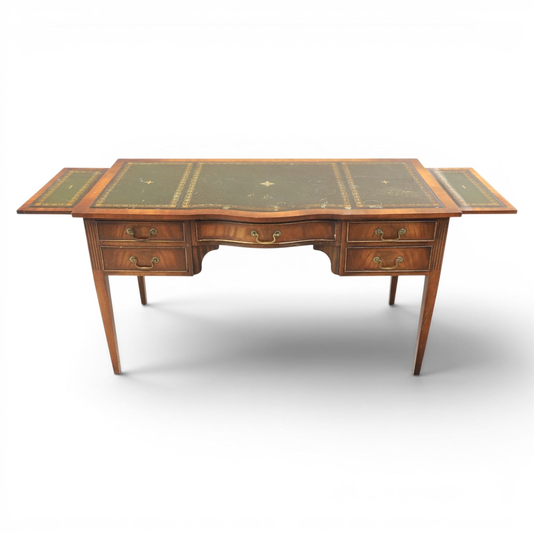 Regency style mahogany writing desk, serpentine front tooled green leather inset, slides to either side, central frieze drawer, flanked by a bank of two drawers, square tapering supports