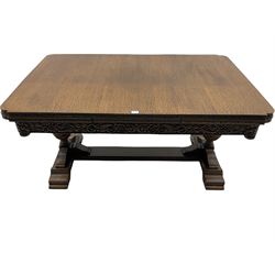 Early 20th century West Yorkshire carved oak dining set - the table with rectangular drawer leaf extending top, the skirt relief carved with flowers and foliage, on twin urn shaped pedestals with lobe carved tops and acanthus leaf bodies, on platform stretcher base (99cm x 153cm - 245cm, H87cm), and set six dining chairs,  high arched backs relief carved with c-scrolls and flower heads, upholstered in brown faux leather, the front supports matching the table pedestals
