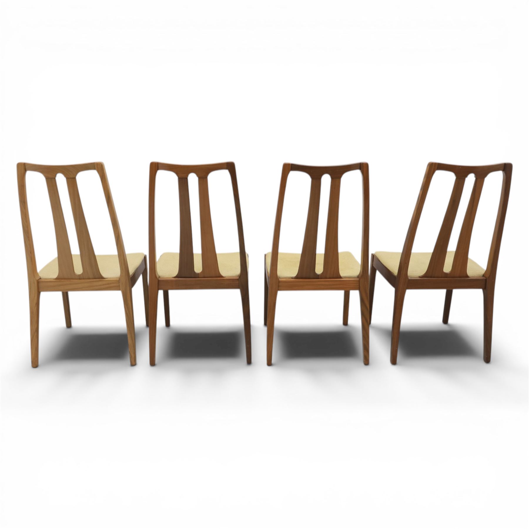 Nathan - teak drop leaf dining table and four Nathan dining chairs, the rectangular top with rounded corners fitted with twin hinged drop leaves and gate legs, extended to form an oval table 174cm in length, raised on square section supports united by stretchers, the chairs with teak frames and padded beige upholstered seat (H 96cm, W 48cm)