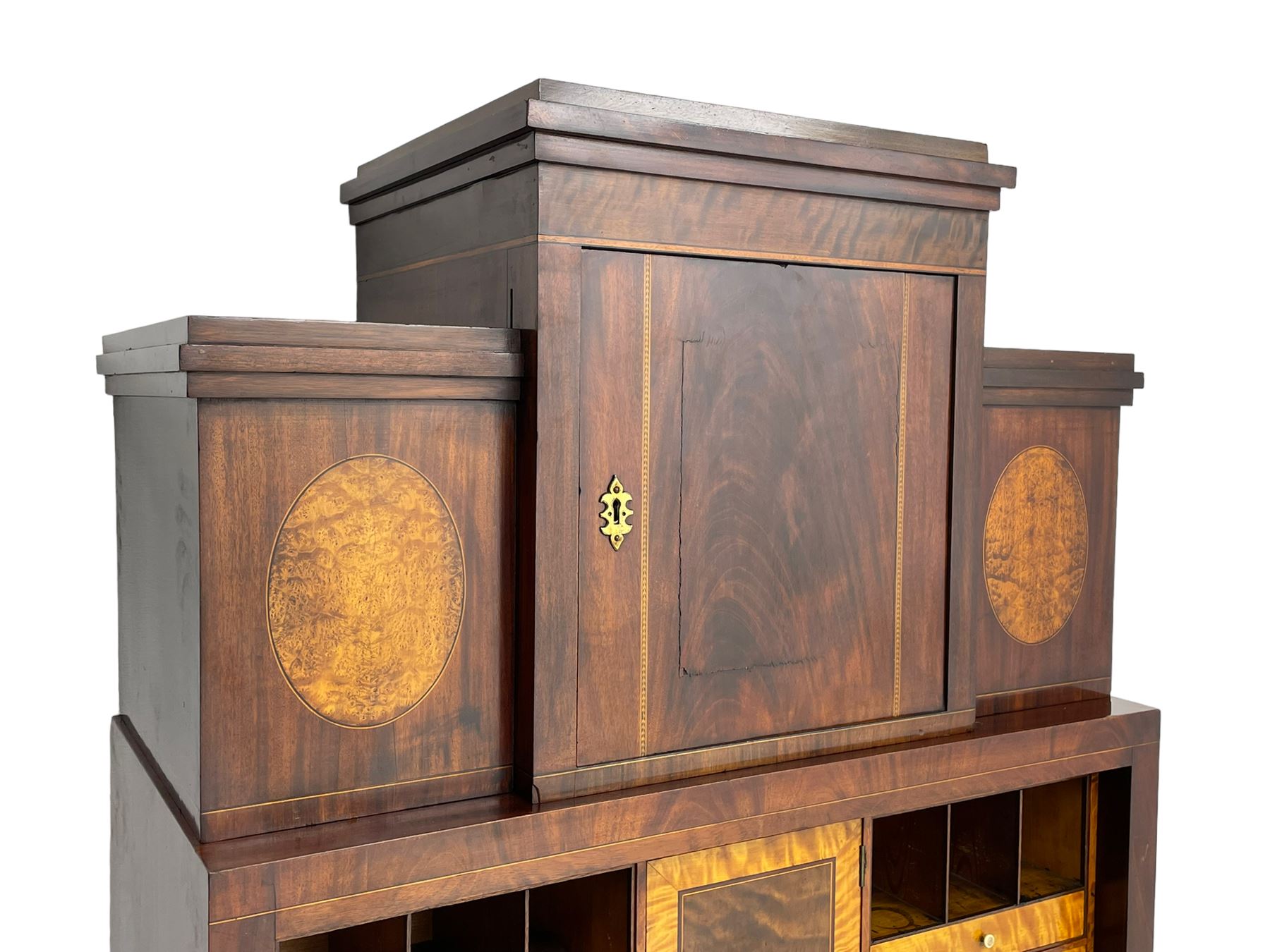 Early to mid-19th century figured mahogany Continental secrétaire à abattant, stepped top fitted with single cupboard, inlaid with oval figured amboyna panels, the fall front inlaid with shell motif enclosing a satinwood interior fitted with cupboard, drawers, and pigeon holes, three long drawers below, on square tapering feet