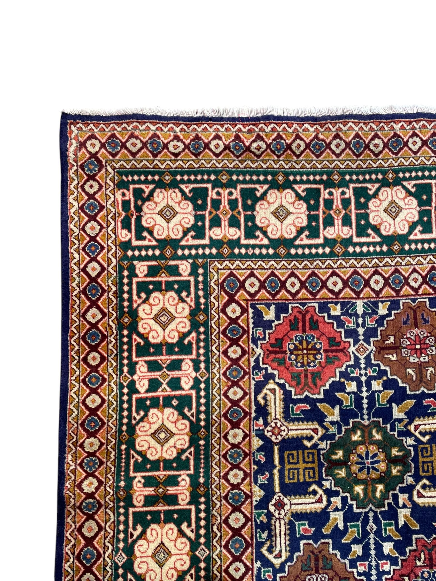 Persian Tabriz indigo ground rug, overall Quba design, decorated with repeating stylised plant motifs and interlaced with trailing leaf motifs, repeating border within geometric guard stripes