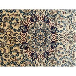 Persian Kashan ivory ground rug, wool with silk inlay, central floral rosette medallion surrounded by trailing flower heads and interlacing leafy branches, the repeating scrolling border decorated with palmettes, within guard stripes