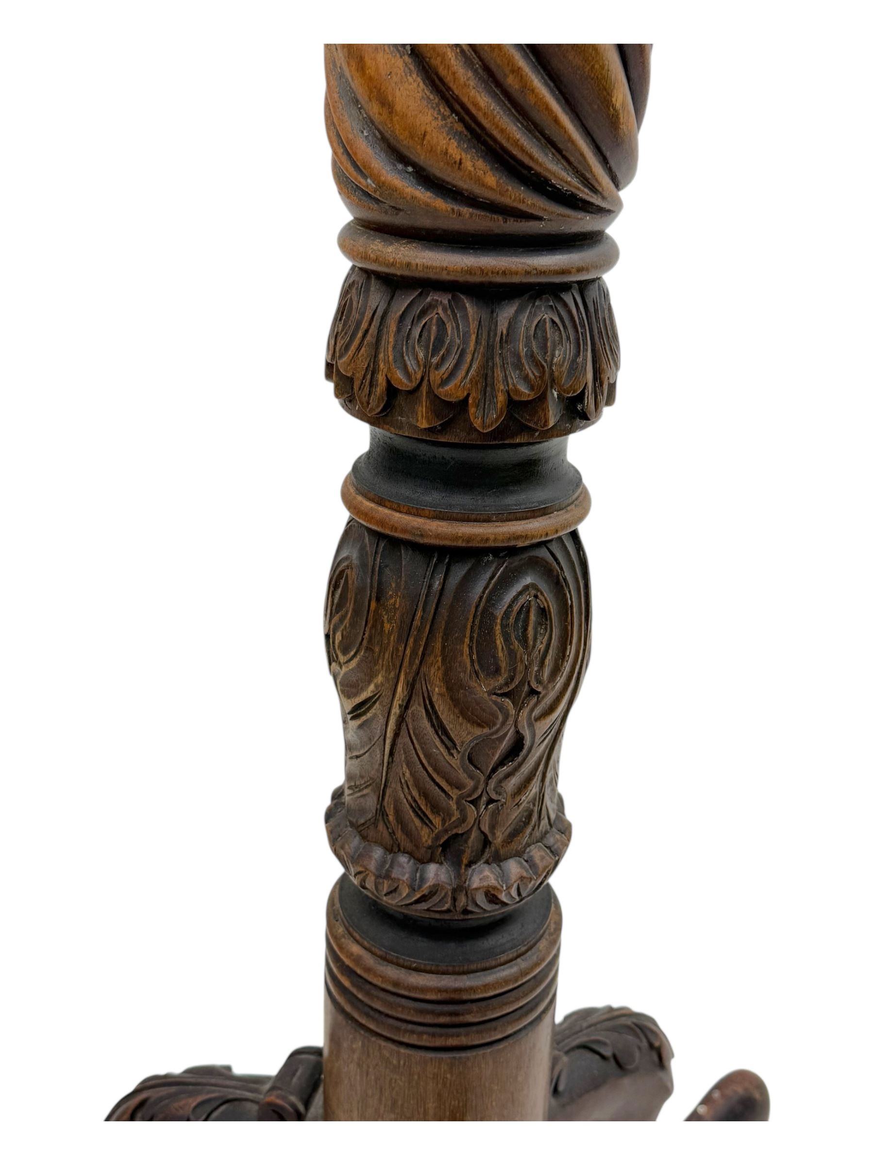 Late 19th century mahogany torchère stand, with circular top above a twisted and foliate carved collumn, on a scroll carved tripod base, on cabriole legs