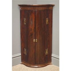  19th/20th century rosewood serpentine front wall hanging corner cabinet, projecting cornice, two cupboard doors enclosing three shelves, W39cm, H67cm, D29cm  