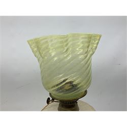 19th century brass oil lamp, the green vaseline glass shade of wrythen and frill form above a clear glass reservoir, raised upon a column with stepped circular base with stylised Art Nouveau motif detail, with clear glass chimney