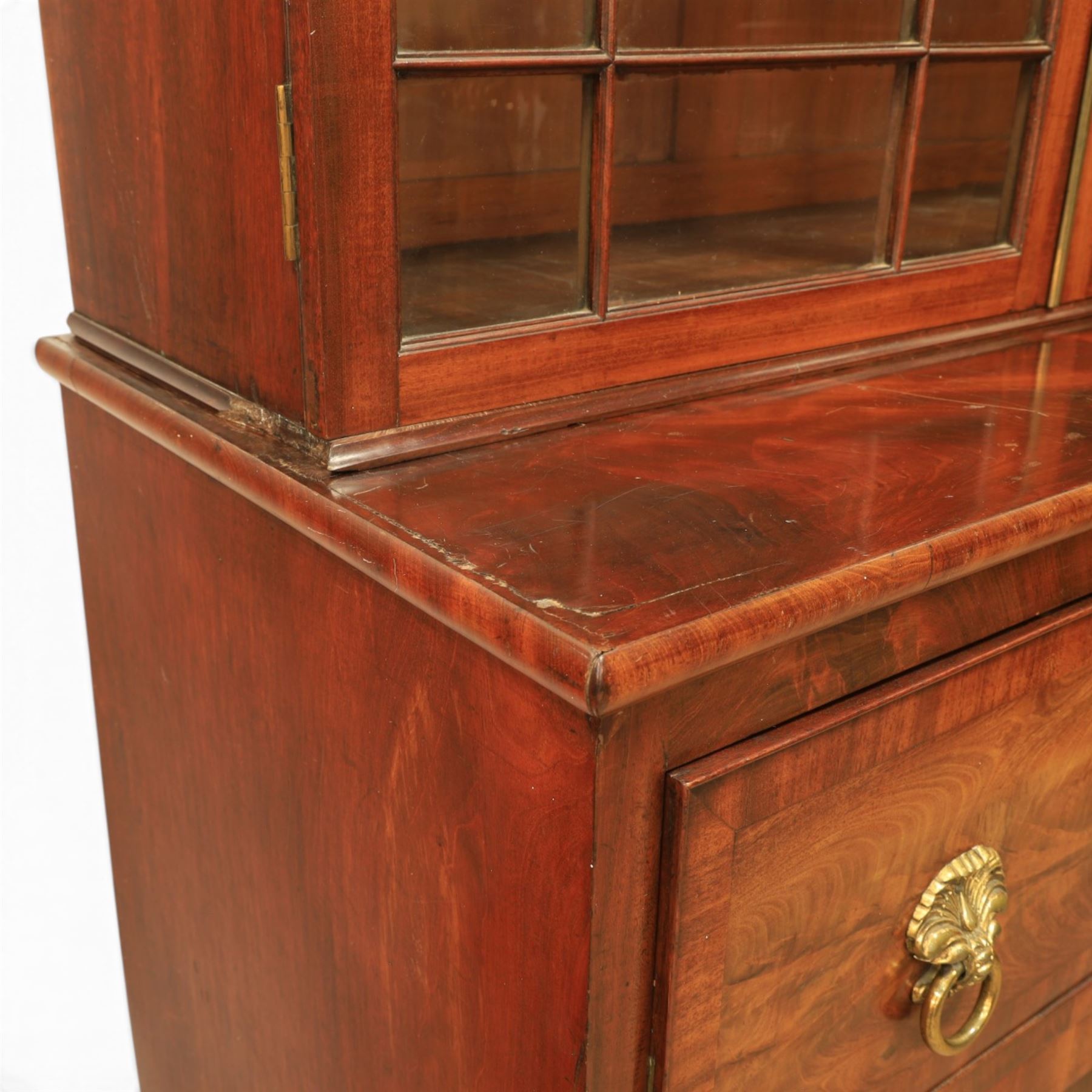 Early 19th century mahogany secretaire-bookcase, projecting cornice above astragal glazed cabinet with adjustable shelved interior, fall front secretaire drawer, fitted interior with pigeonholes and drawers, flame mahogany fronted cabinet with three drawers, on turned supports 