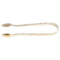 Edwardian silver shell butter dish, upon three bun feet, together with a matching shell spoon engraved with initial, both hallmarked Josiah Williams & Co, London 1906 and 1914, together with an Edwardian milk jug, open sucrier and sugar tongs, the jug and bowl of circular part fluted form with bead rim, hallmarked Mappin & Webb Ltd, Sheffield 1902, both sets contained within fitted tooled leather boxes with silk and velvet lined interiors