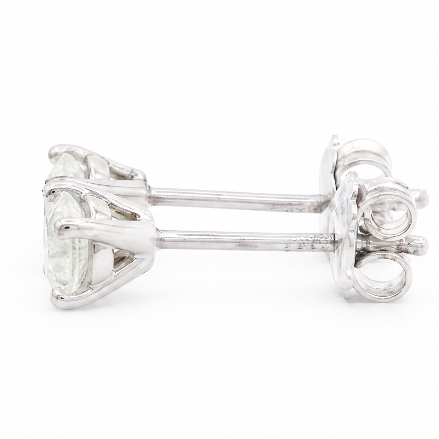 Pair of 18ct white gold diamond earrings, each stud four claw set with a single round brilliant cut diamond, stamped 750, total diamond weight approx 1.05 carat