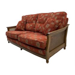 Ercol medium elm framed three seat bergere sofa, and pair of matching armchairs upholstered in red fabric